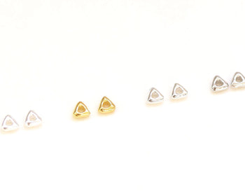 Set of small gold earrings on a white background